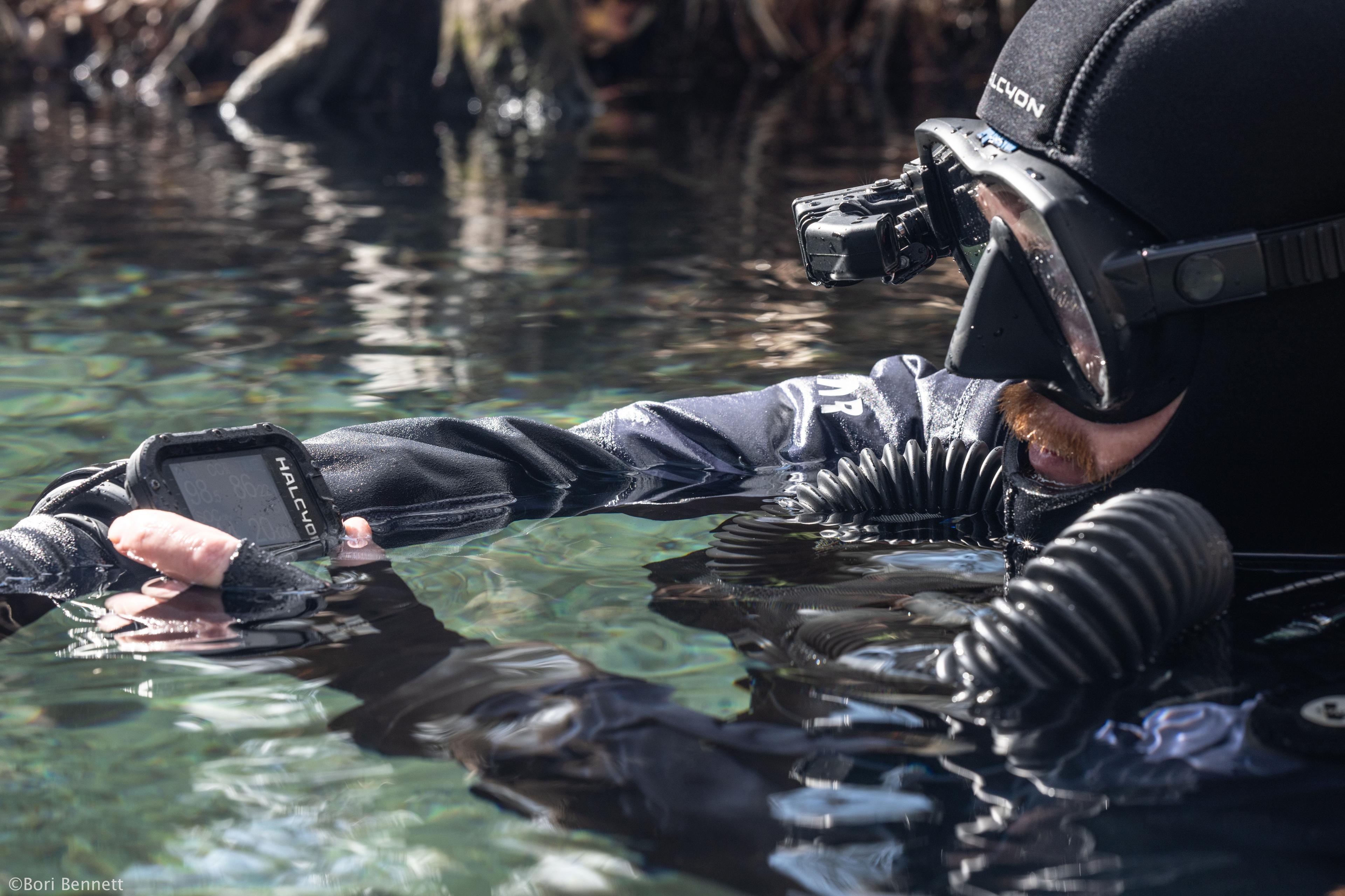 Diver looking at Symbios handset computer at the surface